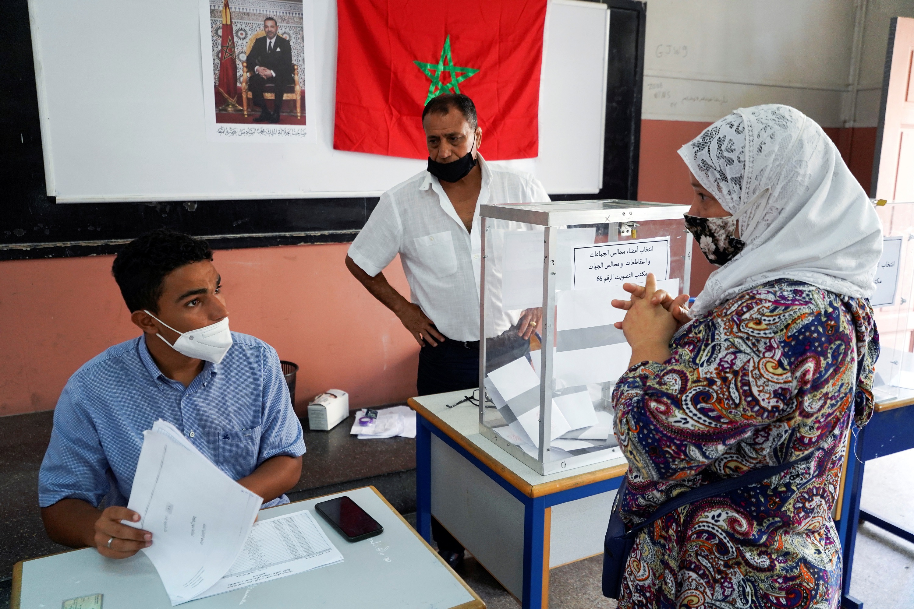 An electoral worker assists a voter at a polling station during parliamentary and local elections, in Casablanca, Morocco, September 8, 2021. REUTERS/Abdelhak Balhaki